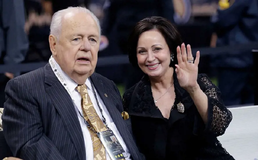 Tom Benson sits on the sideline with his wife, Gayle Benson, before an NFL football game against the Green Bay Packers on Oct. 26 in New Orleans.