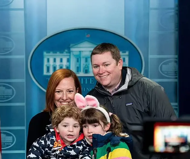 Jen Psaki poses for a photo alongside her husband, Gregory Mecher, and their two children .