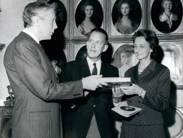  Sir Anthony Blunt, when he was Surveyor of the Queen's pictures, left, presenting the millionth visitor to the Queens Gallery. 