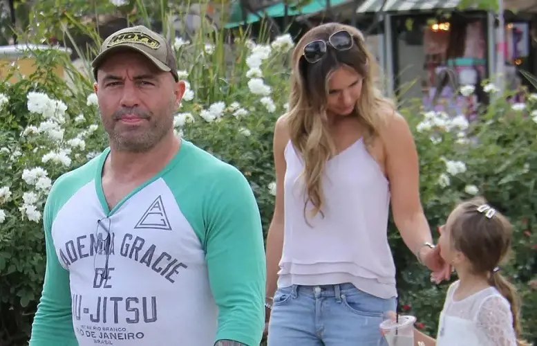 Joe Rogan and his wife walking outside the  shopping mall with their daughters
