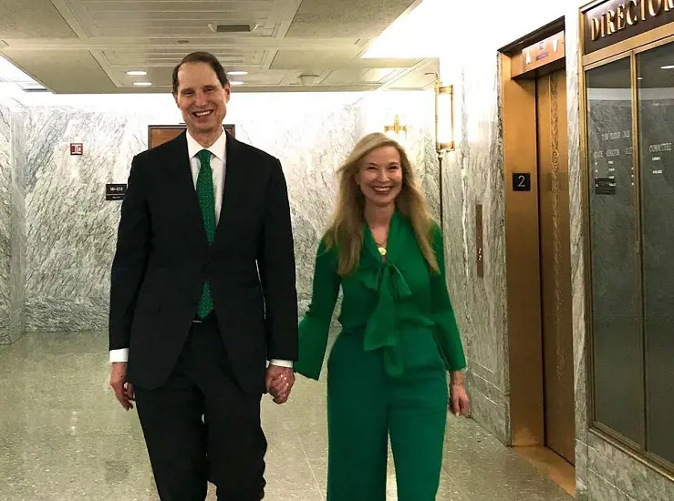 Nancy Wyden and her husband, Ron Wyden, wearing a matching couple outfit. Ron wearing a green tie and Nancy green suit.